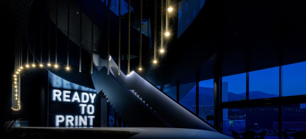Eine pixelige weiße Welle der ikonische Hauptsitz der Durst Group AG. MPV-Design. ph Nachbar Rolf