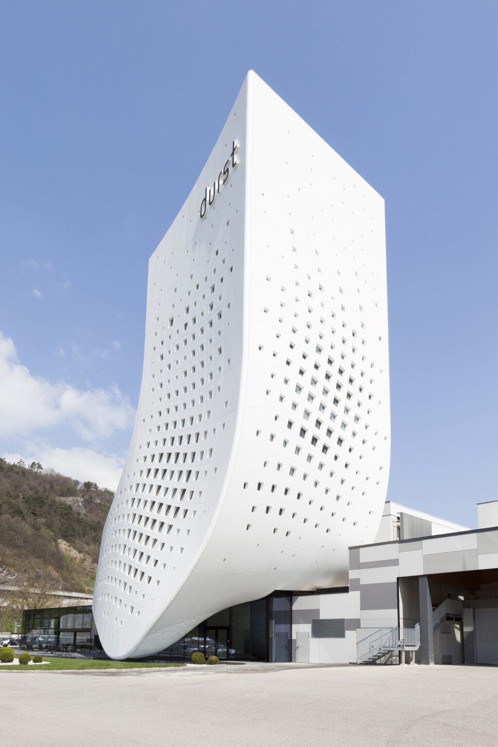 Una ola blanca pixelada en la icónica sede de Durst Group AG. Diseño de monovolúmenes. ph paolo riolzi