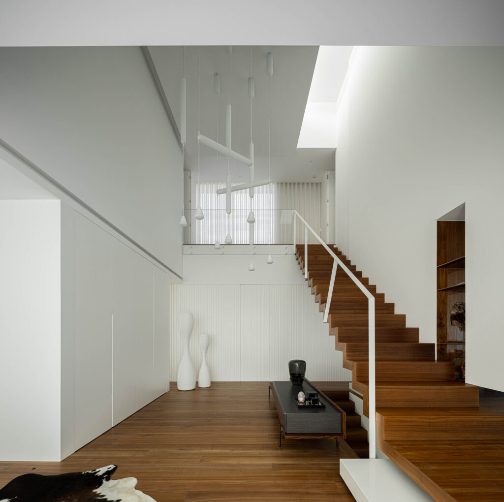 Un silenzioso blocco di cemento bianco rigato la casa che si integra con lintorno attraverso la sua serenita